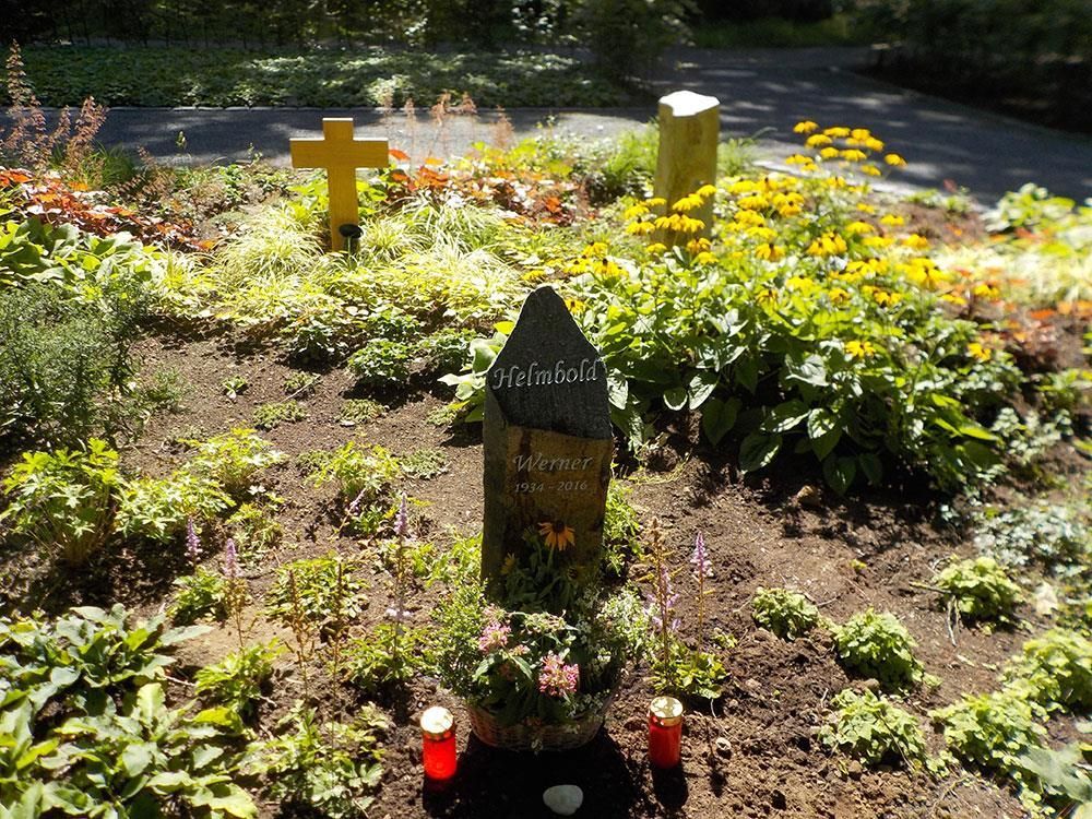 Ein Grab in einem Garten mit Blumen und Kerzen