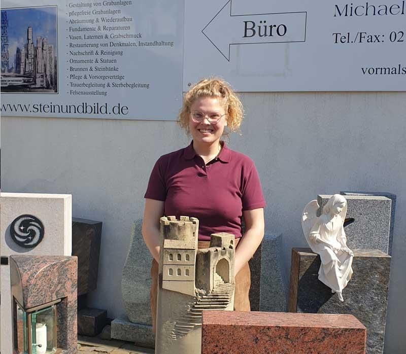 Eine Frau steht vor einem Schild mit der Aufschrift „Büro“