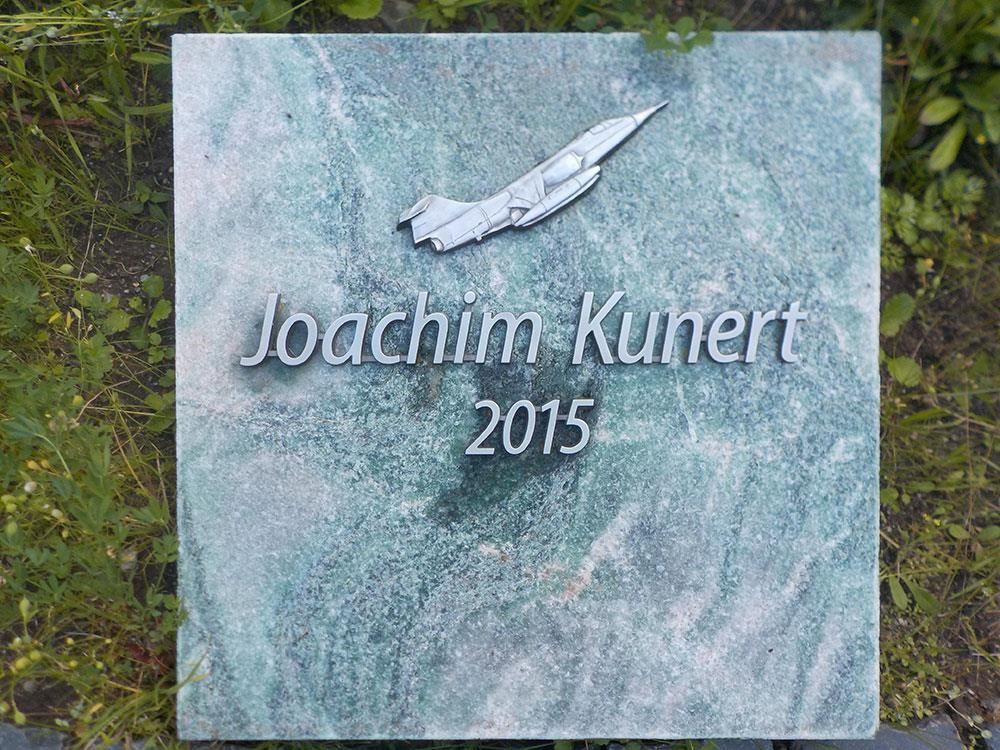 Ein Grabstein  im Jahr 2015 mit einem Flugzeug darauf.
