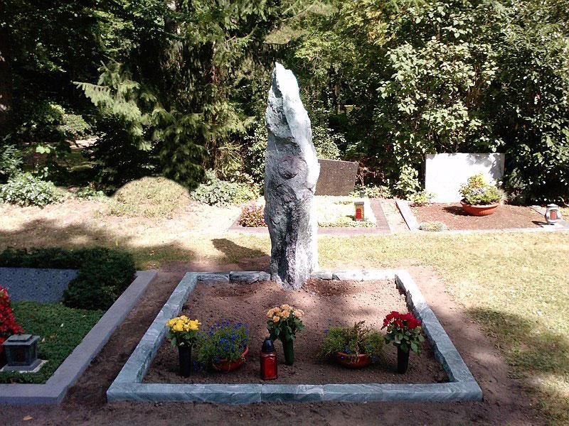 Ein Grab auf einem Friedhof mit Blumen und Kerzen