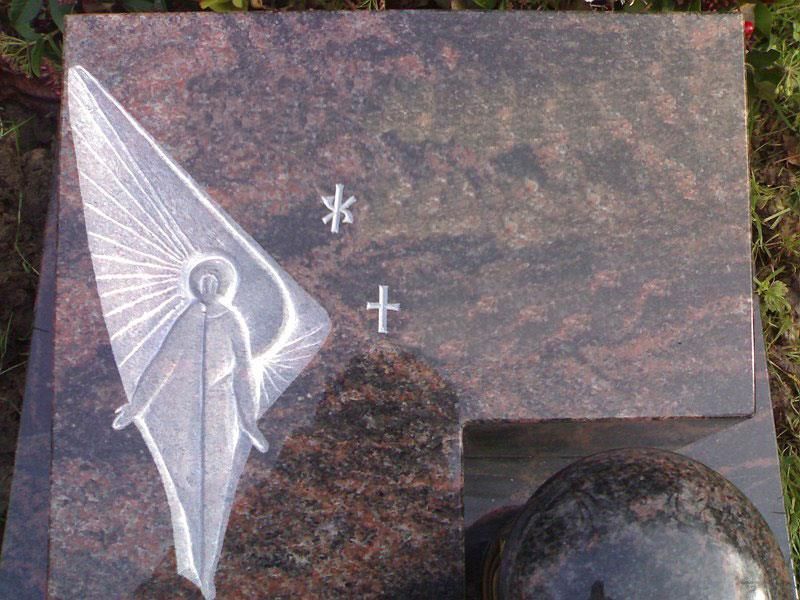 Ein Grabstein mit der Zeichnung eines Engels darauf.
