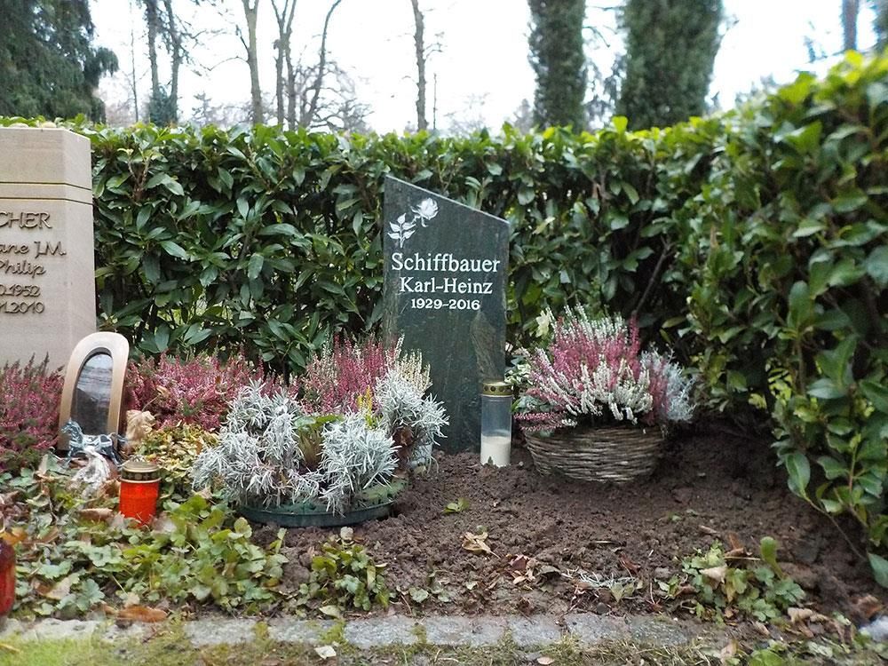 Ein Grab auf einem Friedhof mit einem Grabstein, auf dem Schiffbauer steht
