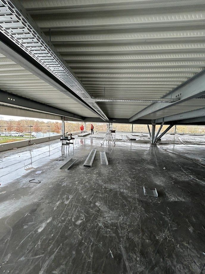 Plusieurs chemins pour câbles fixés au plafond dans un parking protégé