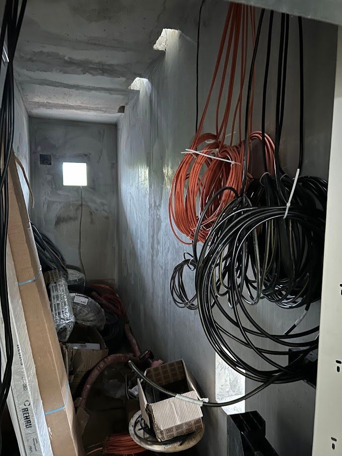 Deux câbles rouge et noir enroulés sur eux-mêmes dans un local technique