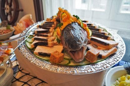 A plate of food with a fish on top of it on a table.