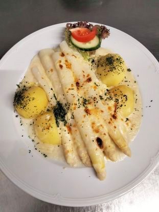 A white plate topped with white asparagus and potatoes
