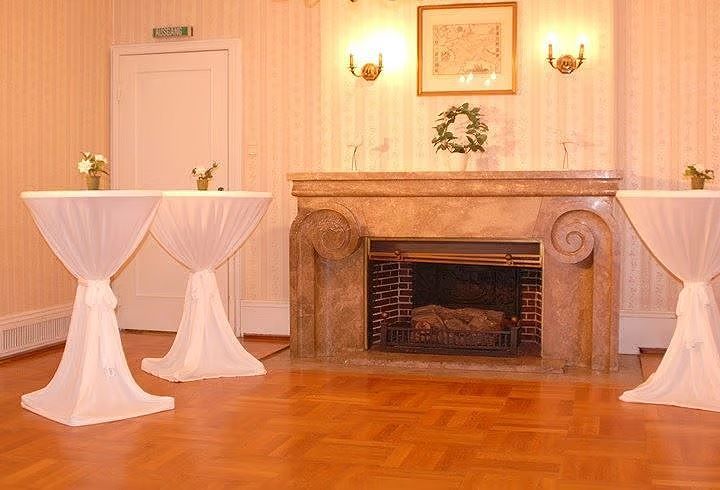 A fireplace with two tables in front of it