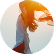Una mujer está parada en un círculo con su cabello ondeando al viento.