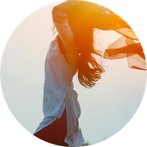 Una mujer está parada en un círculo con su cabello ondeando al viento.