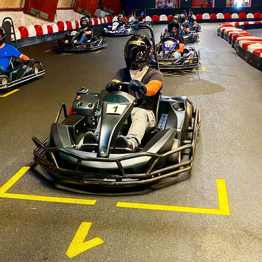 Eine Gruppe von Leuten fährt mit Go-Karts auf einer Strecke.