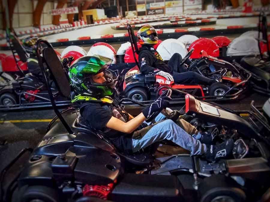 Eine Gruppe von Leuten fährt mit Go-Karts auf einer Strecke.