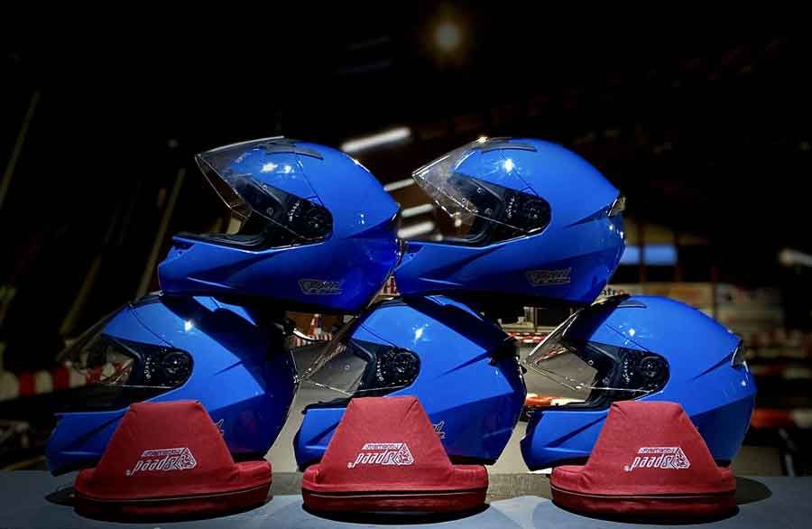 Eine Gruppe blauer Motorradhelme ist auf einem Tisch übereinander gestapelt.