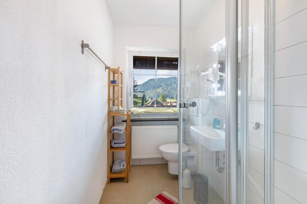 Ein Badezimmer mit Toilette, Waschbecken, Dusche und Fenster.