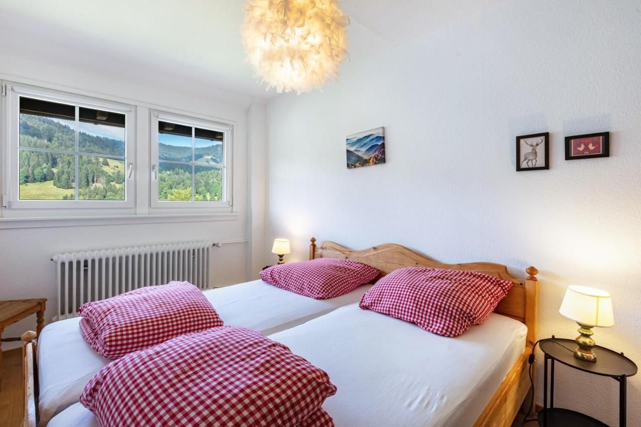 Ein Schlafzimmer mit zwei Betten, zwei Lampen und einem Fenster.