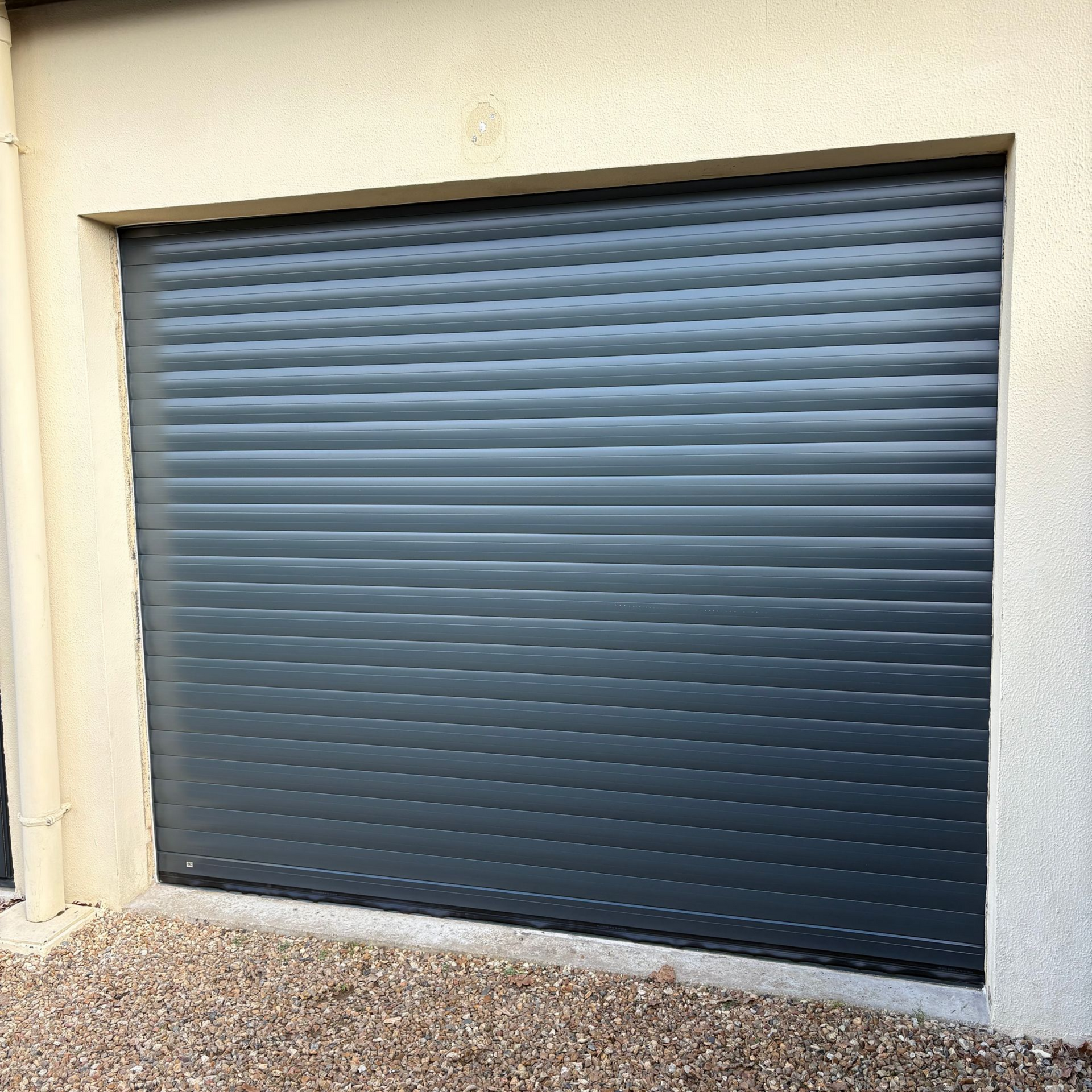 Porte de garage roulante gris foncé.