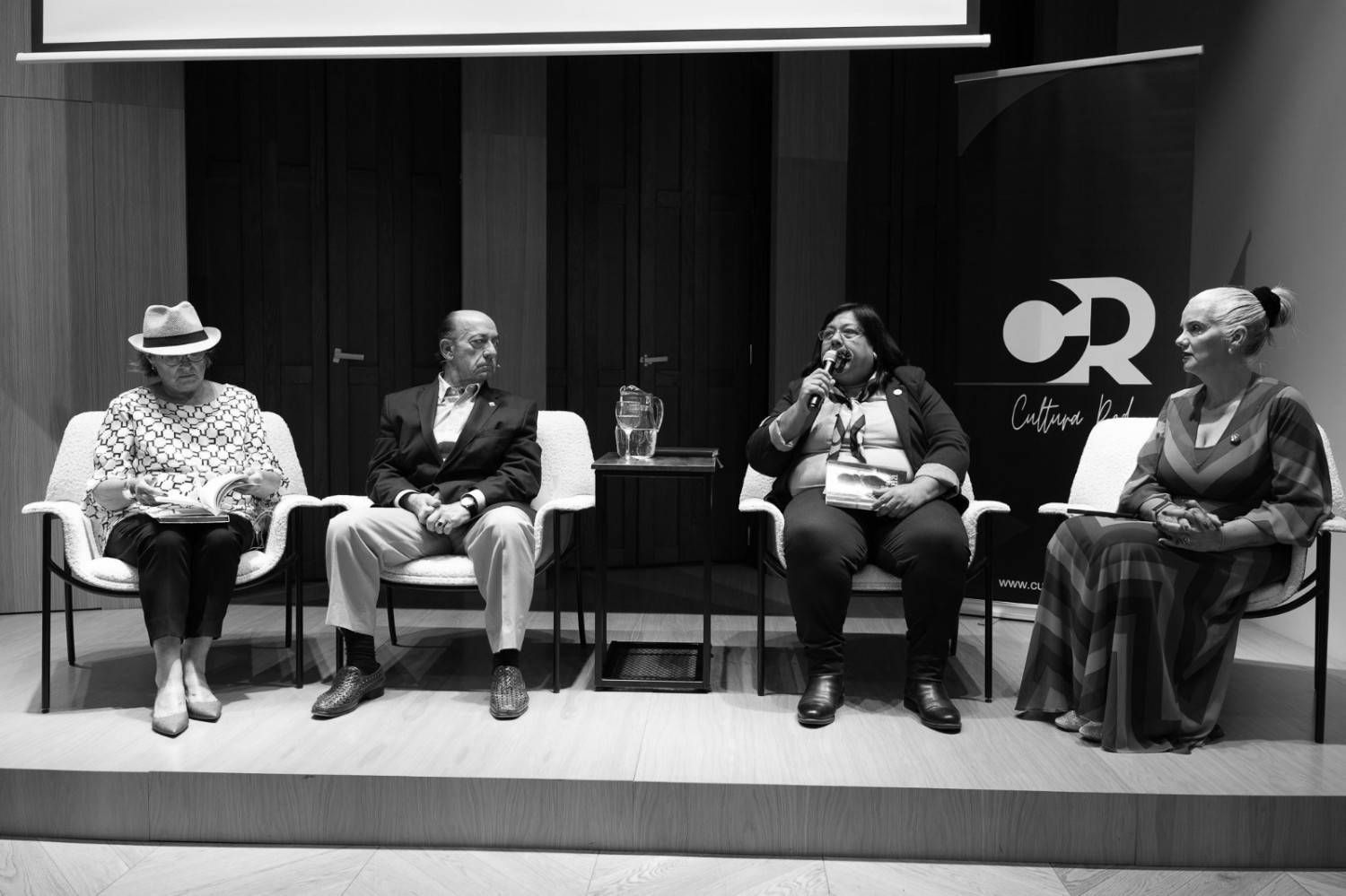 Dos personas leyendo libros al aire libre.