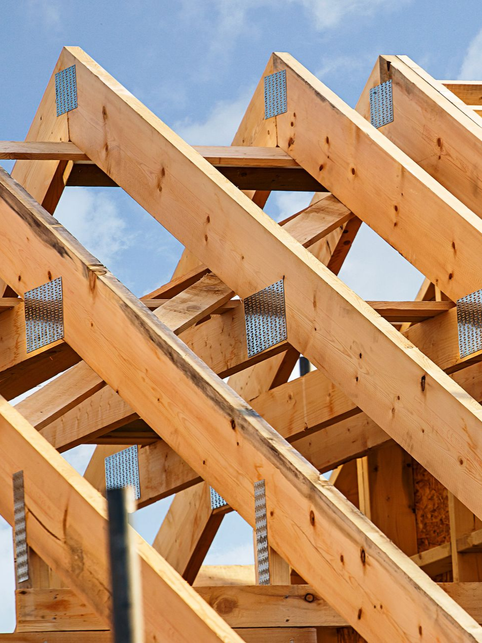 Charpente de toit en bois en construction sur fond de ciel bleu