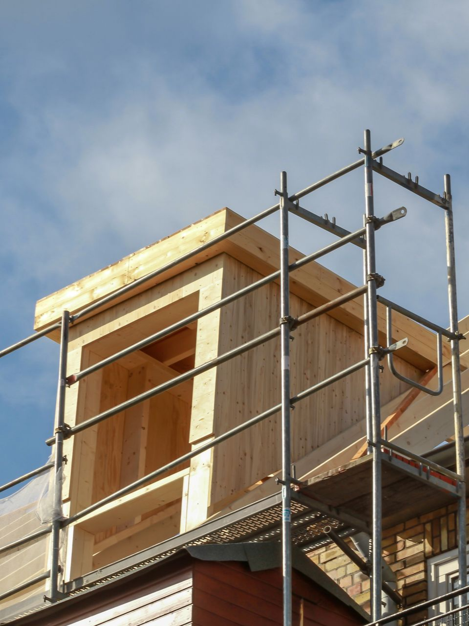 Maison en construction avec échafaudages sur fond de ciel bleu