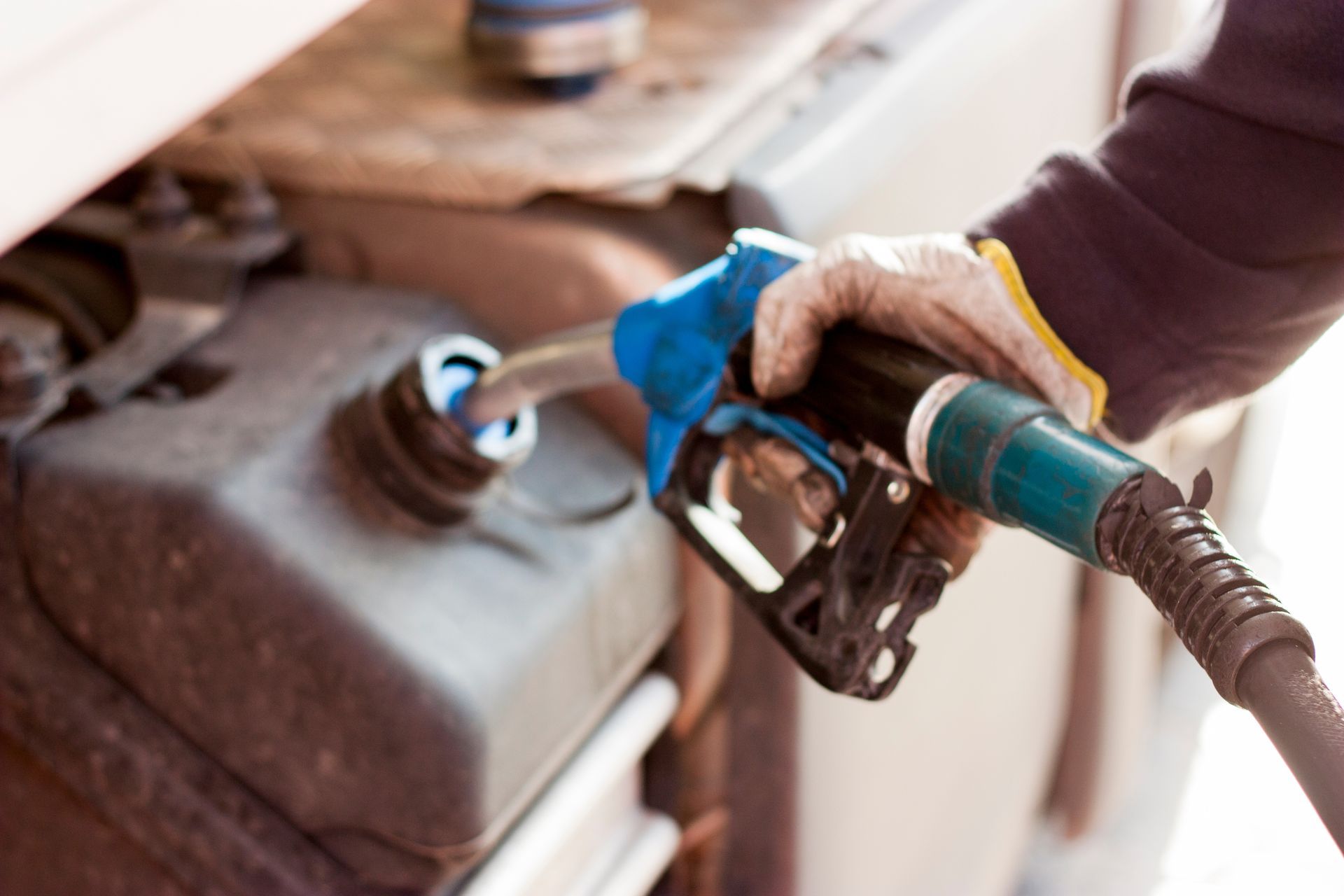 Main dans la main, ravitaillement du réservoir du véhicule avec une pompe à essence.