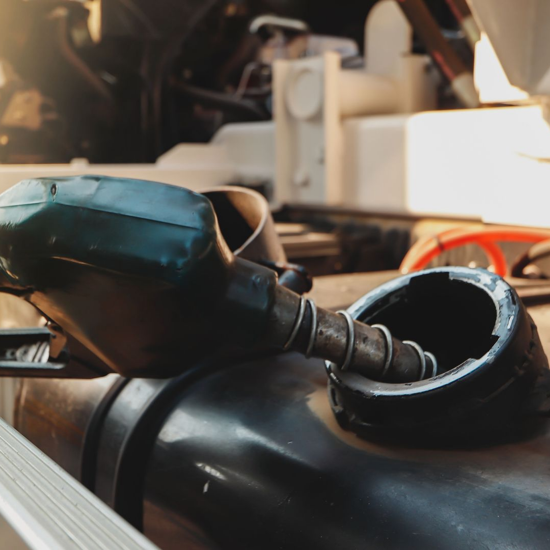 Buse de carburant dans un réservoir de gaz ouvert, versant du carburant.