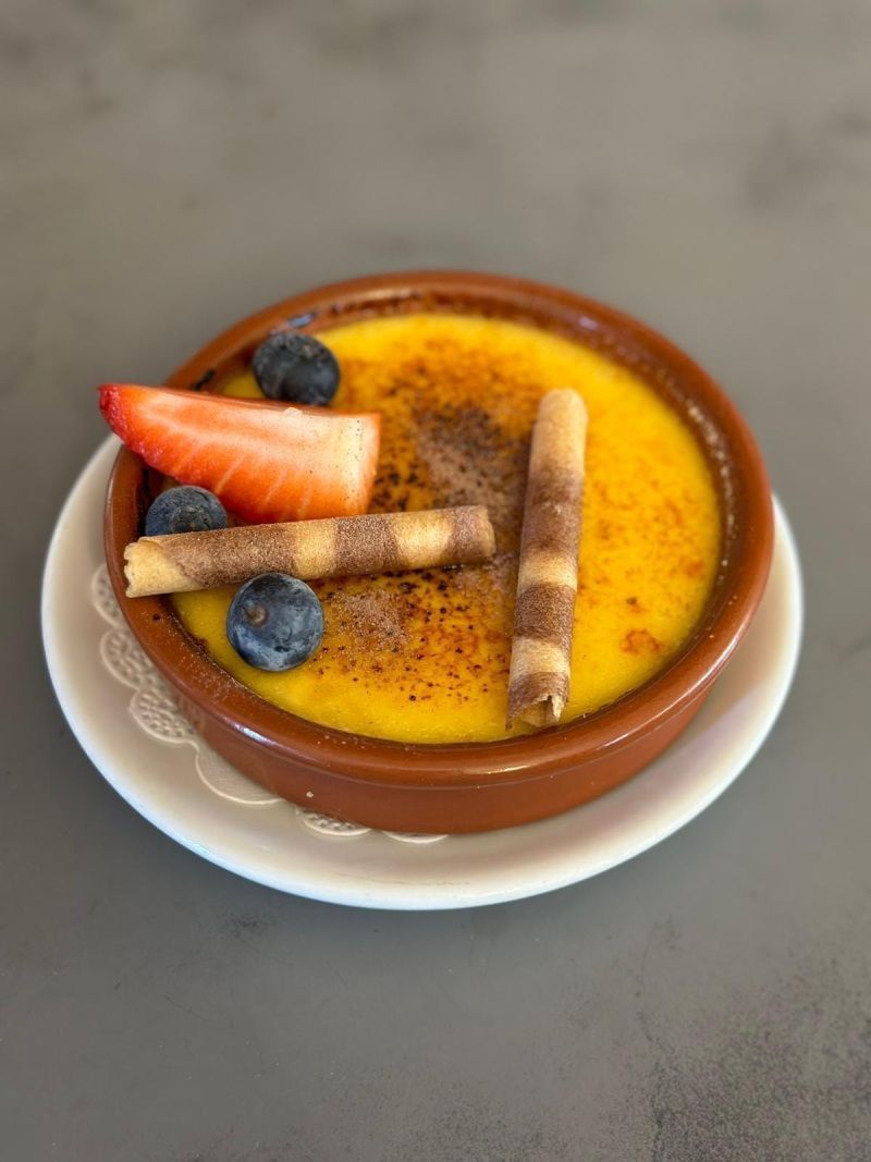 Un petit bol de dessert avec des fraises et des myrtilles sur une assiette.