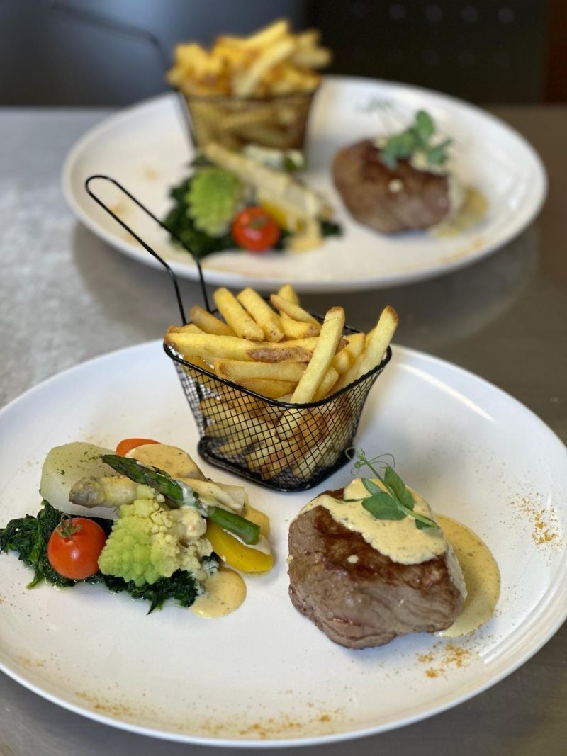 Une assiette de nourriture avec un panier de frites dessus