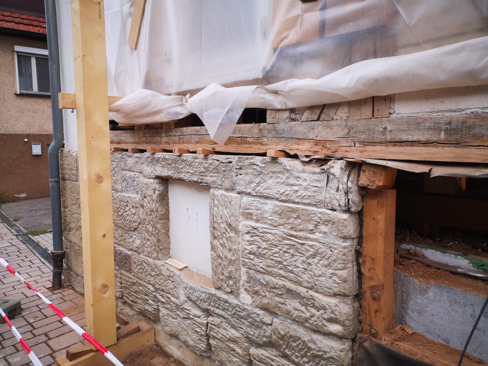 Es wird eine Steinmauer mit einem Loch darin gebaut.