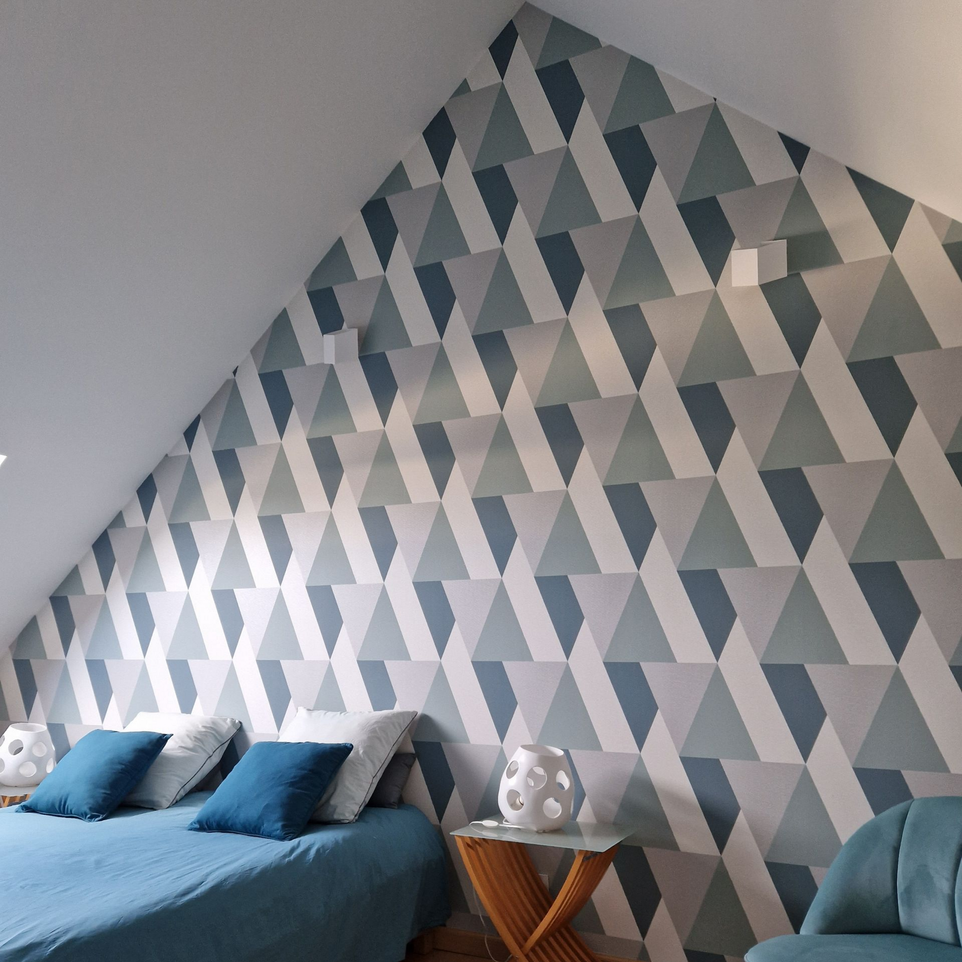 Un papier peint aux formes géométriques de différentes couleurs dans une chambre