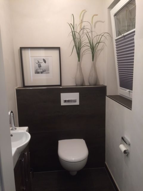 Ein Badezimmer mit Toilette, Waschbecken und einem Bild an der Wand