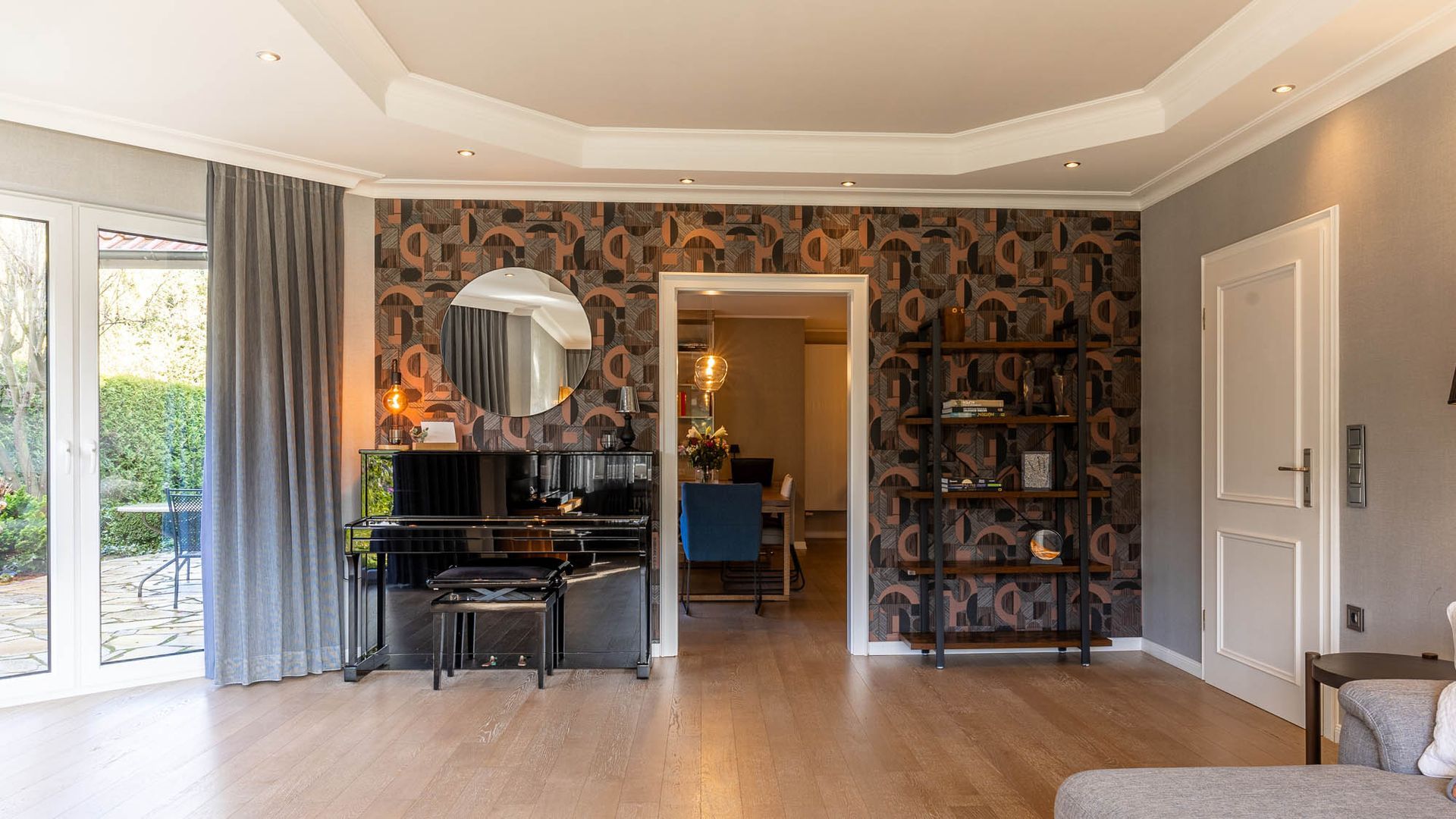 Ein Wohnzimmer mit Klavier, Couch und Spiegel.