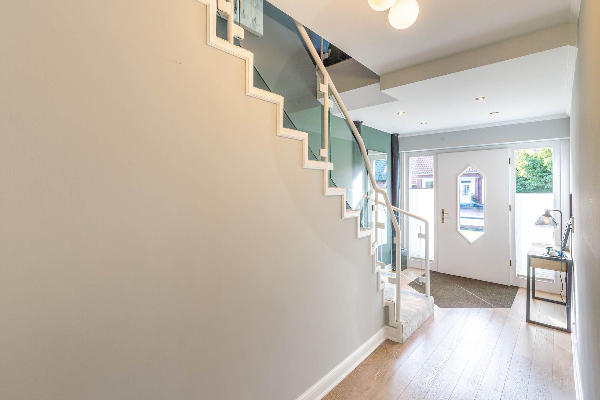 Ein Flur mit einer Treppe, die in den zweiten Stock eines Hauses führt.