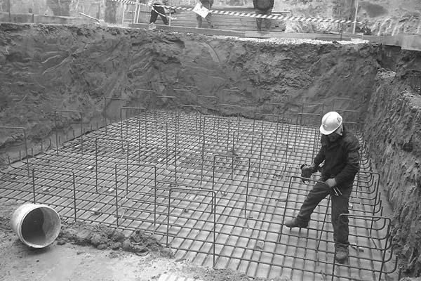 Una fotografía en blanco y negro de un hombre trabajando en un sitio de construcción.