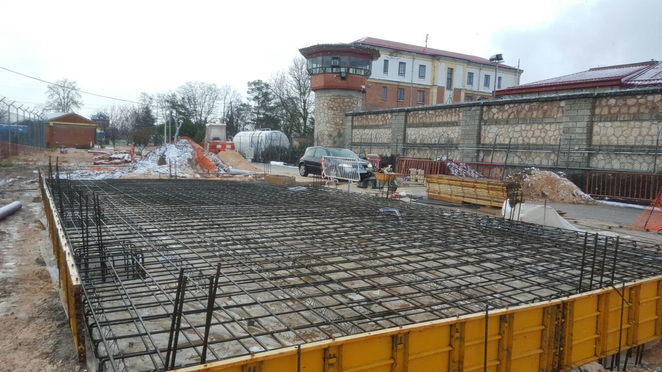 Un sitio de construcción con un gran edificio al fondo.