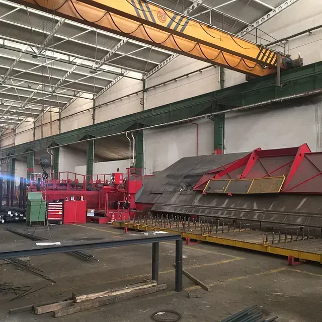 Un gran almacén con una grúa amarilla colgando del techo.