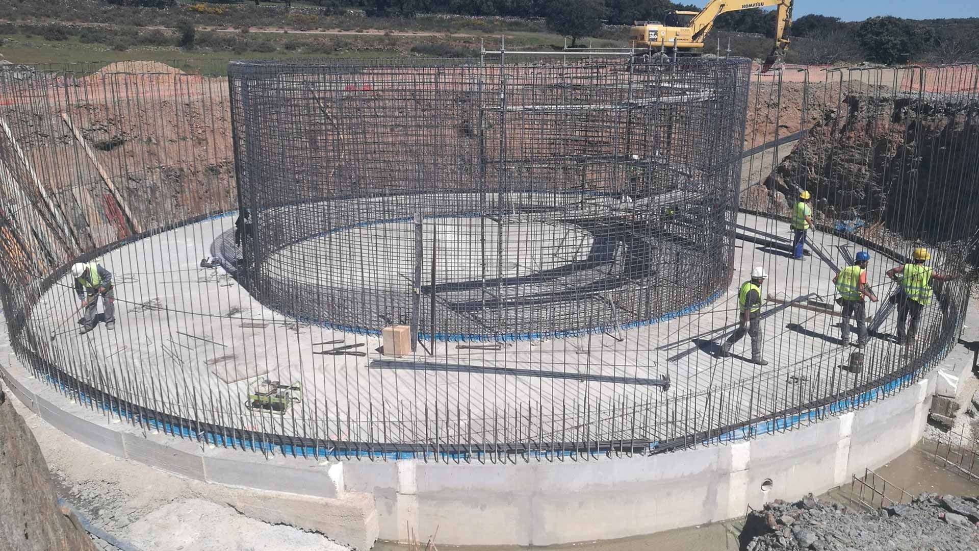 Un grupo de trabajadores de la construcción está trabajando en una gran estructura circular.
