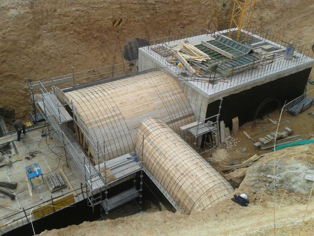 Una vista aérea de un edificio en construcción con una grúa al fondo.
