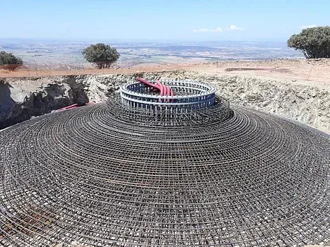 Se está construyendo una gran estructura circular en medio de un campo.
