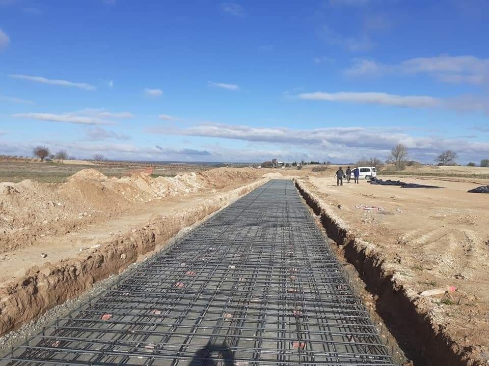 Se está construyendo una carretera de hormigón en un campo de tierra.