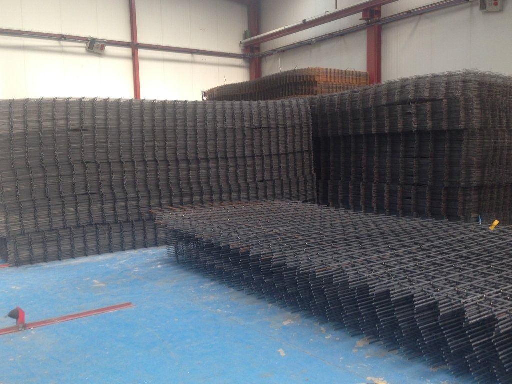 Un almacén lleno de montones de mallas de alambre apiladas una encima de otra.