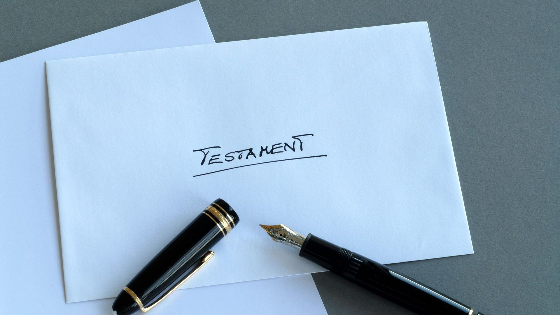 Stylo à plume posé sur un papier où est écrit « testament »