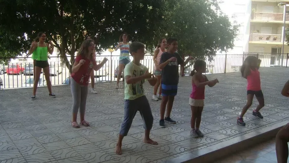 Um grupo de crianças está dançando em um parque