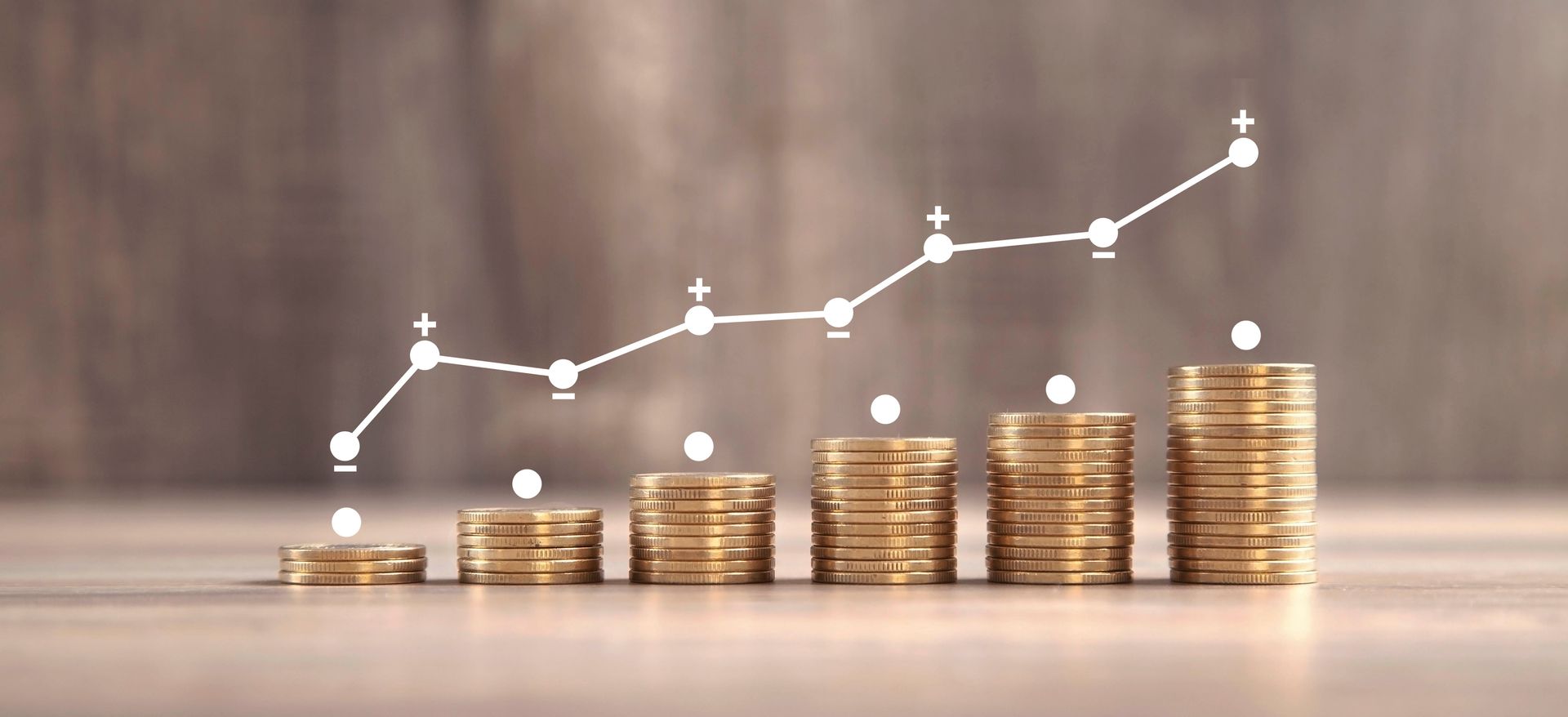 Münzstapel mit einer weißen Aufwärtstrendlinie, die das finanzielle Wachstum im Laufe der Zeit darstellt.