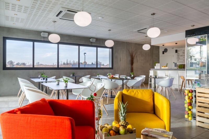 Fauteuil jaune et fauteuil orange dans salle de restauration