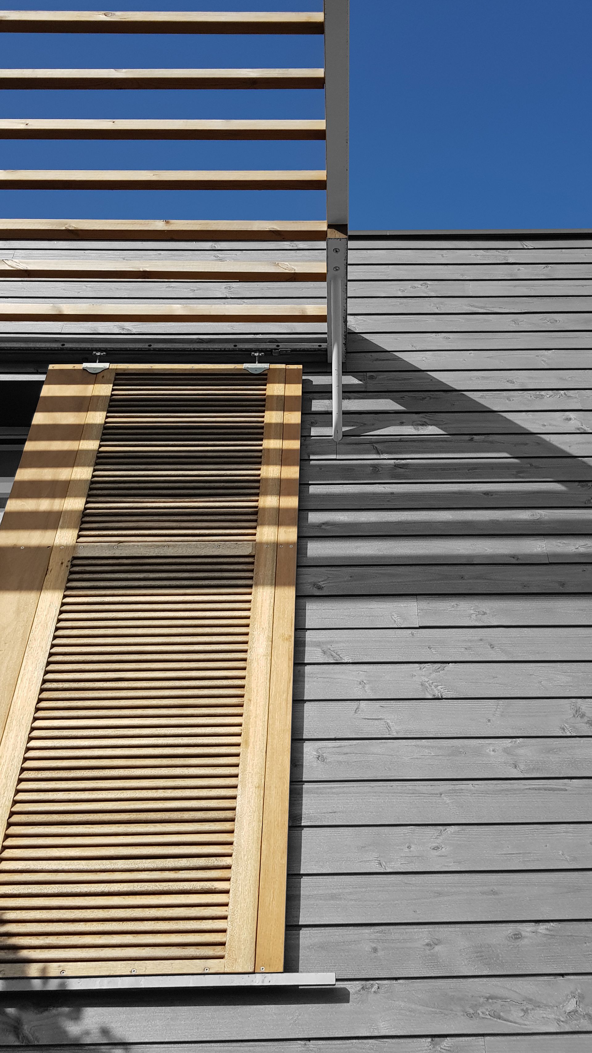 Volet en bois sur bardage en bois gris