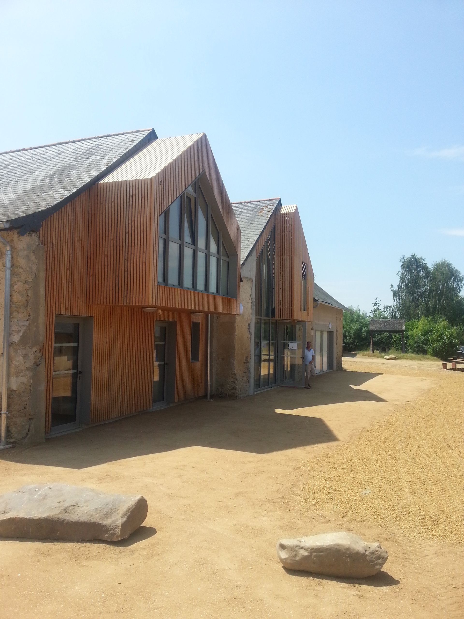 Corps de ferme avec bardage en bois et fenêtres anthracites