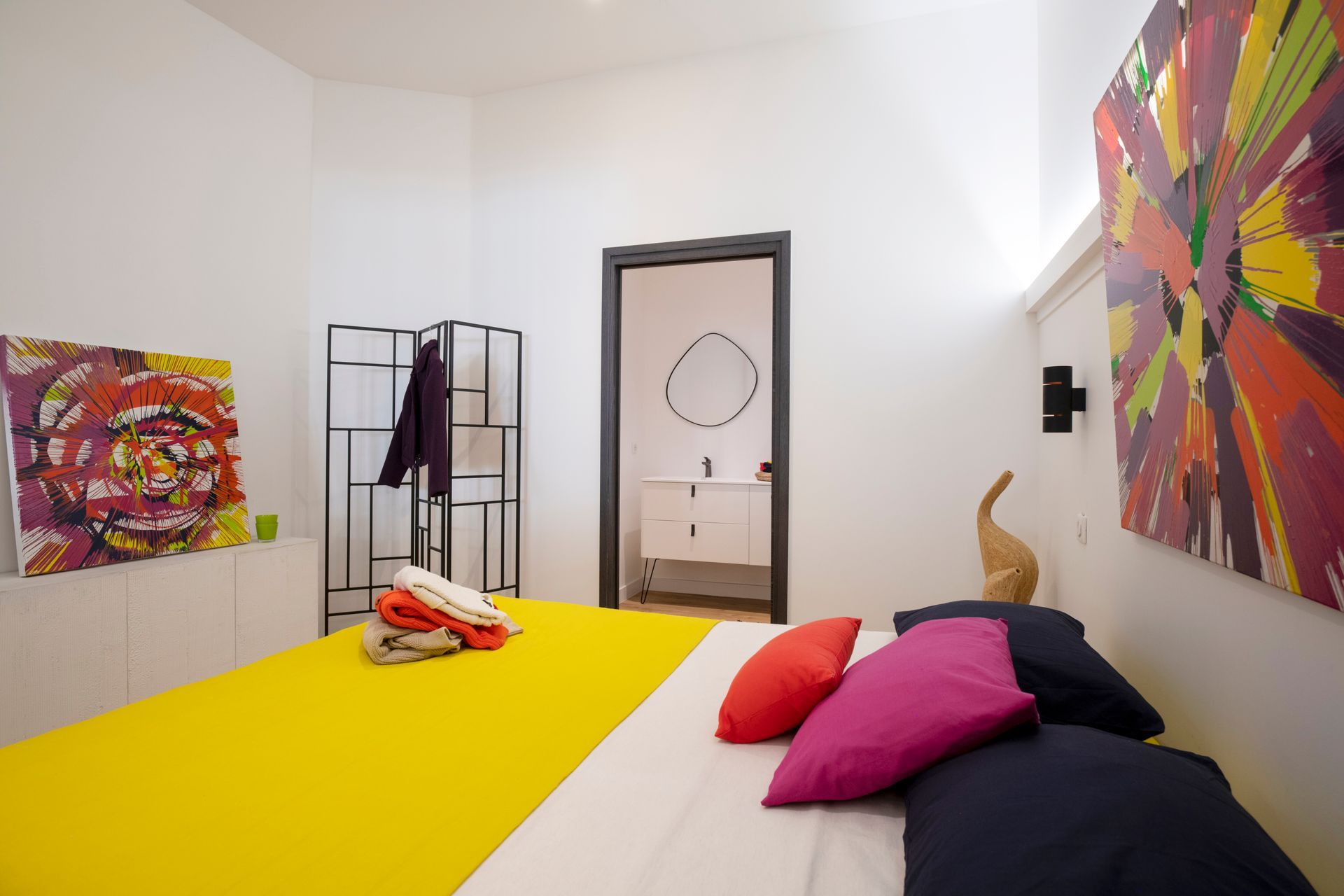 Lit avec oreillers noirs, roses et rouges