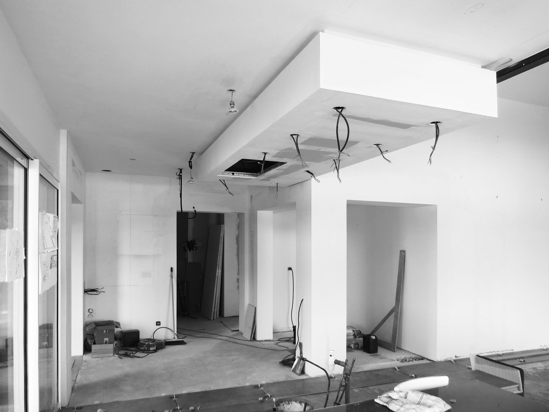 Photo en noir et blanc de travaux en cours d'un plafond avec des spots