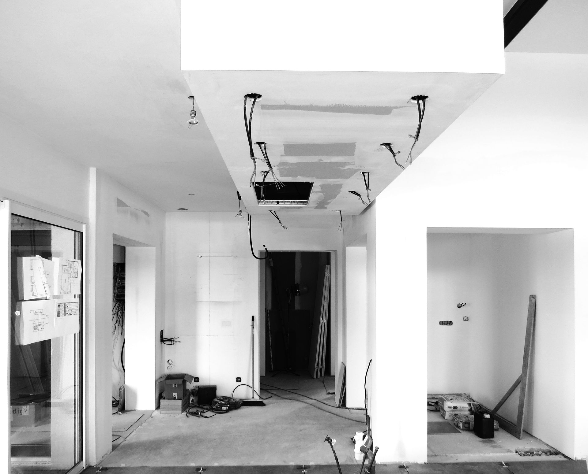 Photo en noir et blanc de travaux en cours d'un plafond avec des spots de lumière