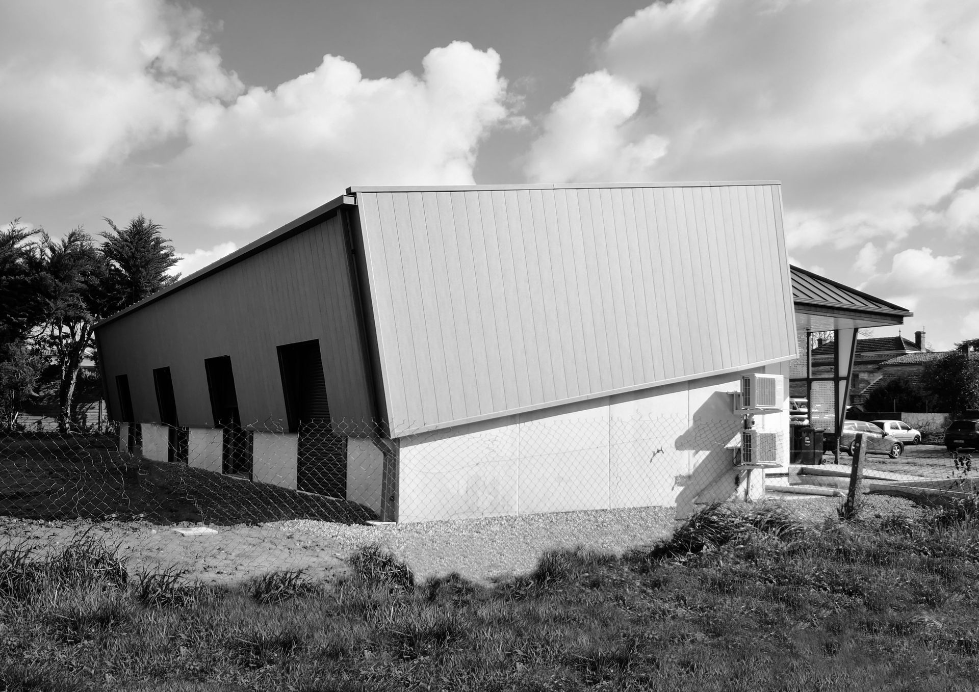 Photo noire et blanche d'un bâtiment avec un toit penché