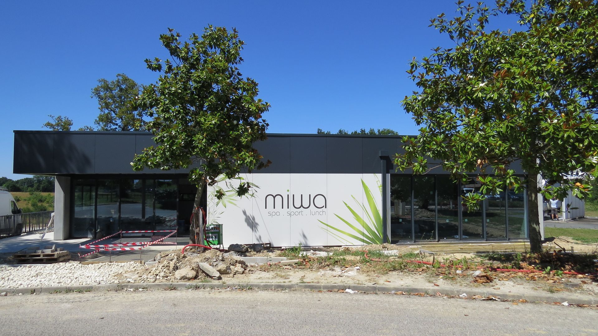 Extérieur d'un bâtiment refait à neuf devant deux arbres